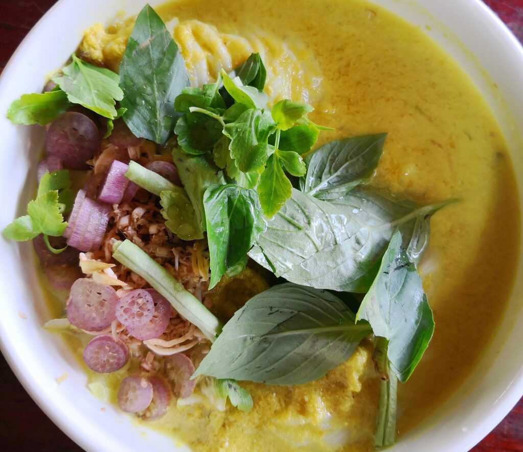 A bowl of num banh chok with fresh accompaniments